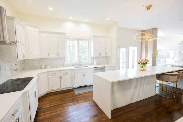 a kitchen with white cabinets and sink
