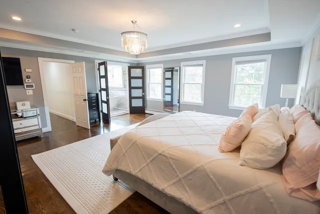 a bed sitting in a spacious bedroom next to a window