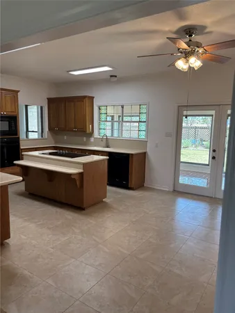 a large kitchen with kitchen island a sink stainless steel appliances and cabinets