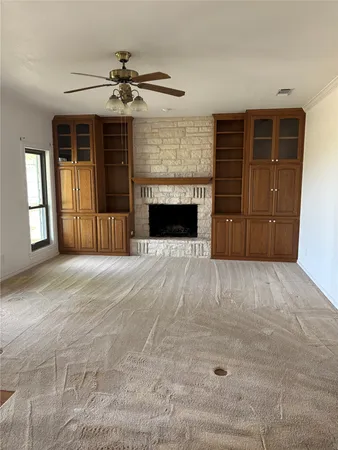 a view of a livingroom with a fireplace cabinet and a window