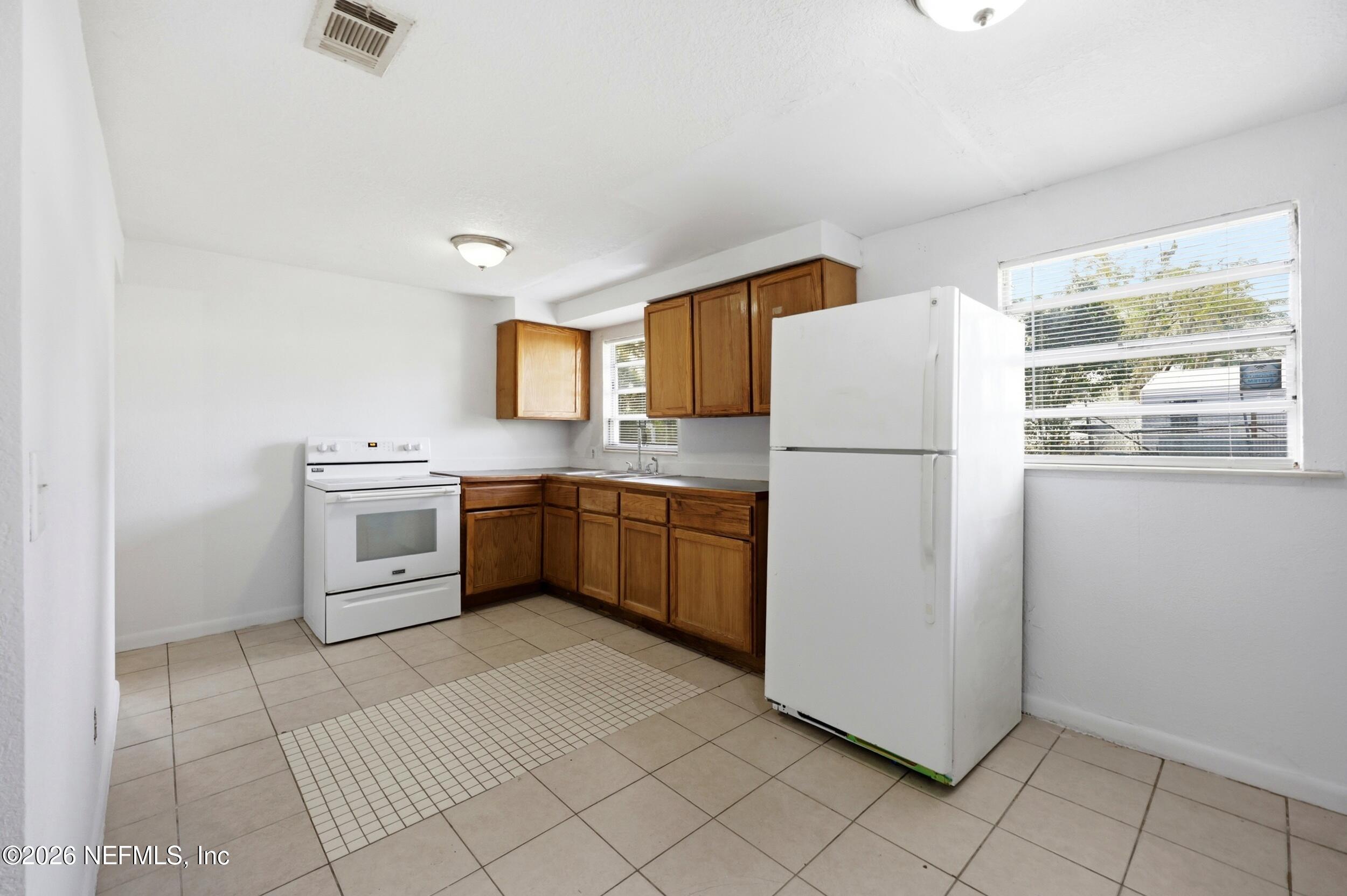 9843 Wagner Road Jacksonville, FL 32219 - Photo 9 of 40 a kitchen with a white refrigerator sink and cabinets