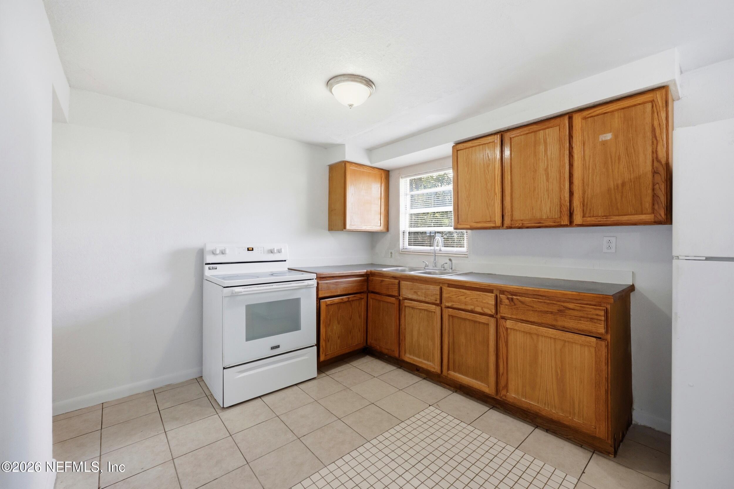 9843 Wagner Road Jacksonville, FL 32219 - Photo 10 of 40 a kitchen with a stove sink and cabinets