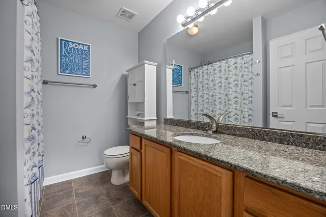 a view of an empty room and chandelier fan