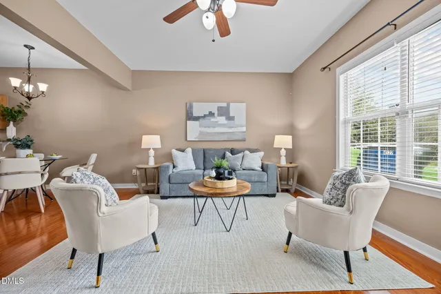a living room with furniture large window and wooden floor