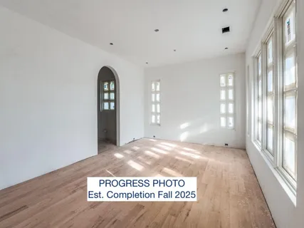a view of an empty room with a fireplace and a window