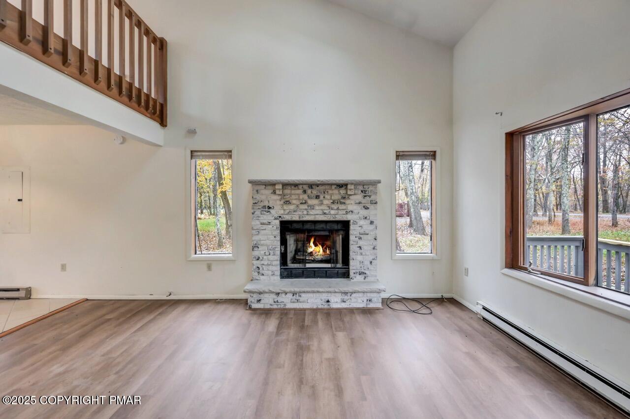38 Spokane Road Albrightsville, PA 18210 - Photo 13 of 69 a view of an empty room with wooden floor windows and a fireplace
