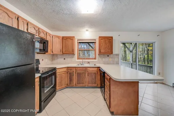 a kitchen with stainless steel appliances granite countertop a refrigerator stove and sink