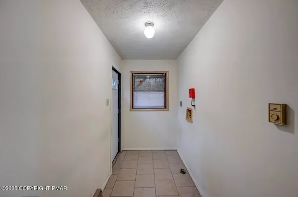 a view of an empty room and chandelier fan