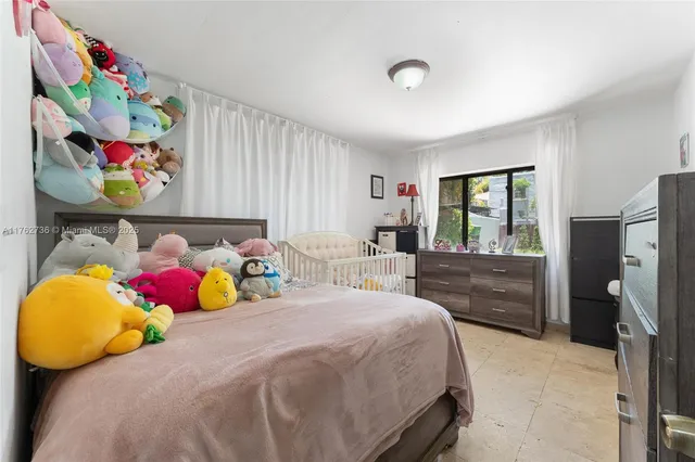 a bedroom with a bed a window and dresser