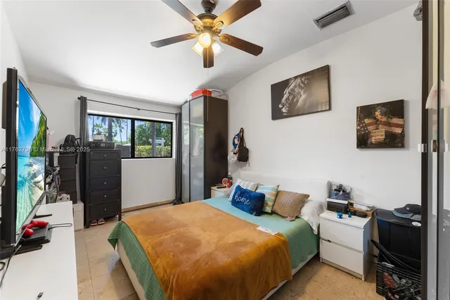 a bed room with a bed furniture and a flat tv screen
