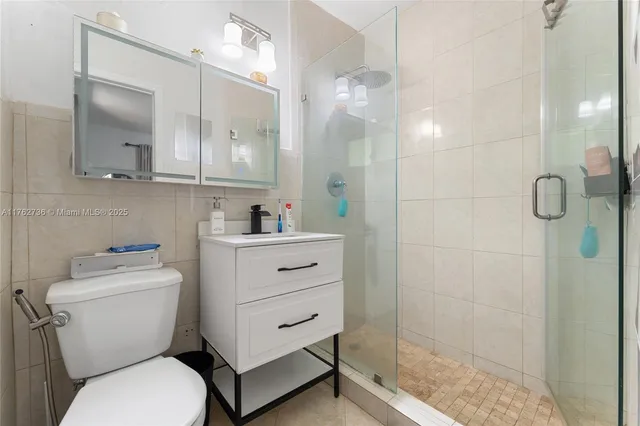 a bathroom with a toilet sink vanity and shower