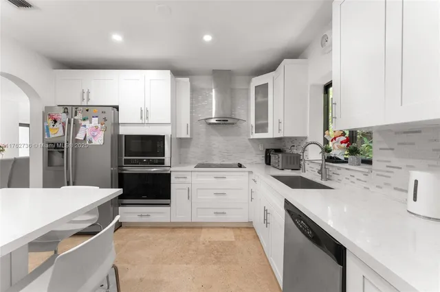 a kitchen with stainless steel appliances a sink dishwasher stove refrigerator and microwave