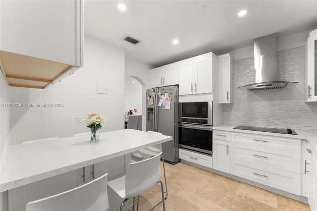 a kitchen with a sink stainless steel appliances and white cabinets