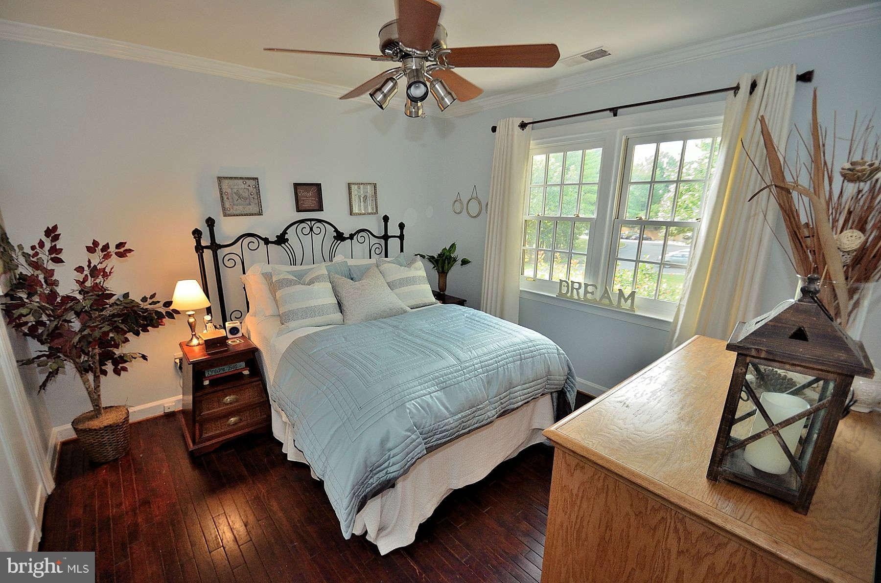 8521 Forrester Boulevard Springfield, VA 22152 - Photo 16 of 28 a bedroom with a bed and potted plants with the wooden floor