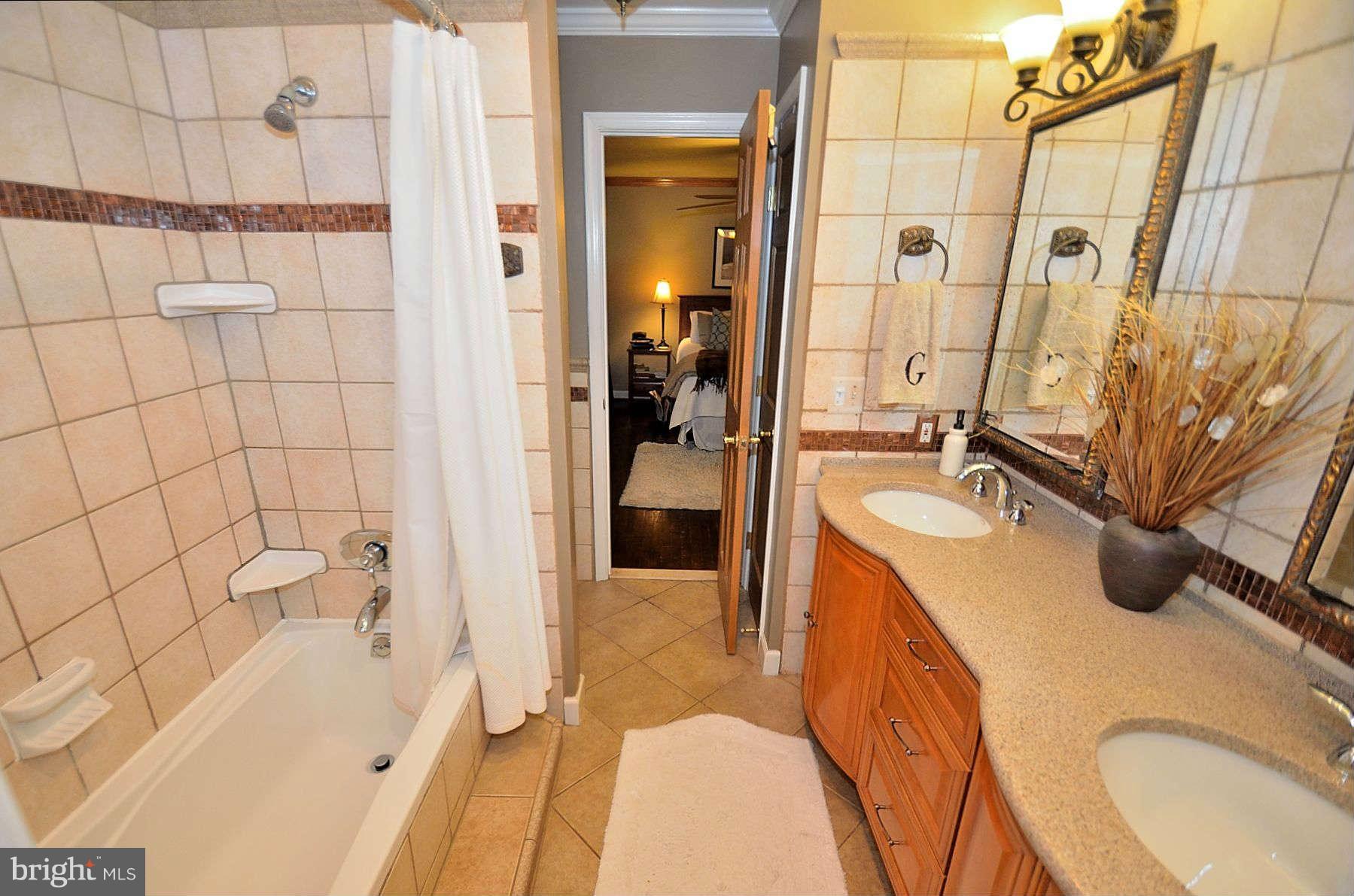 8521 Forrester Boulevard Springfield, VA 22152 - Photo 18 of 28 a bathroom with a sink a granite tub and shower