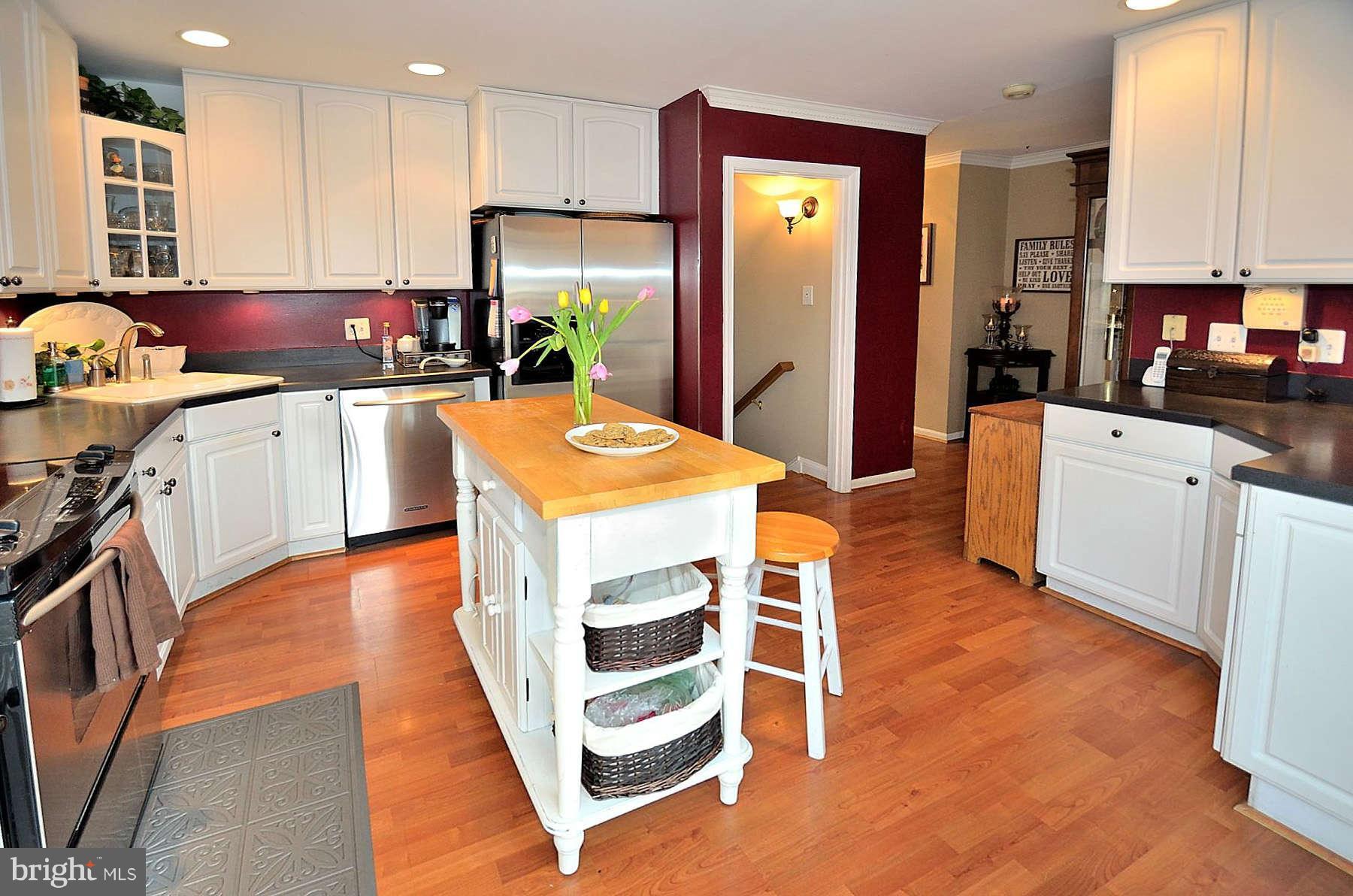 8521 Forrester Boulevard Springfield, VA 22152 - Photo 4 of 28 a kitchen with stainless steel appliances granite countertop a refrigerator a stove a sink and white cabinets with wooden floor