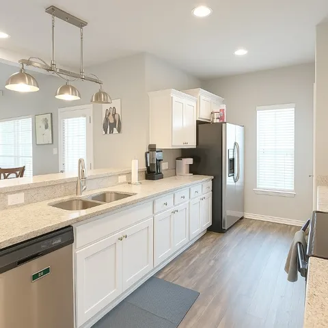 a kitchen with a sink dishwasher a refrigerator and cabinets