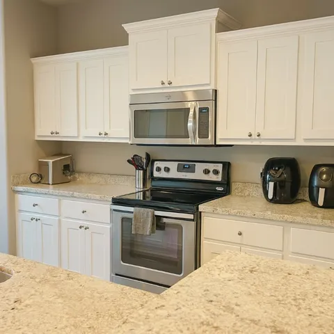 a kitchen with stainless steel appliances granite countertop a stove a microwave and cabinets