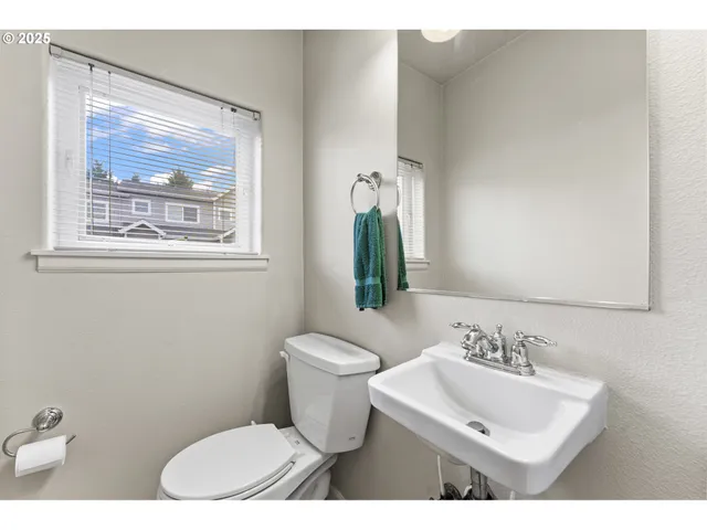a bathroom with a toilet a sink and mirror