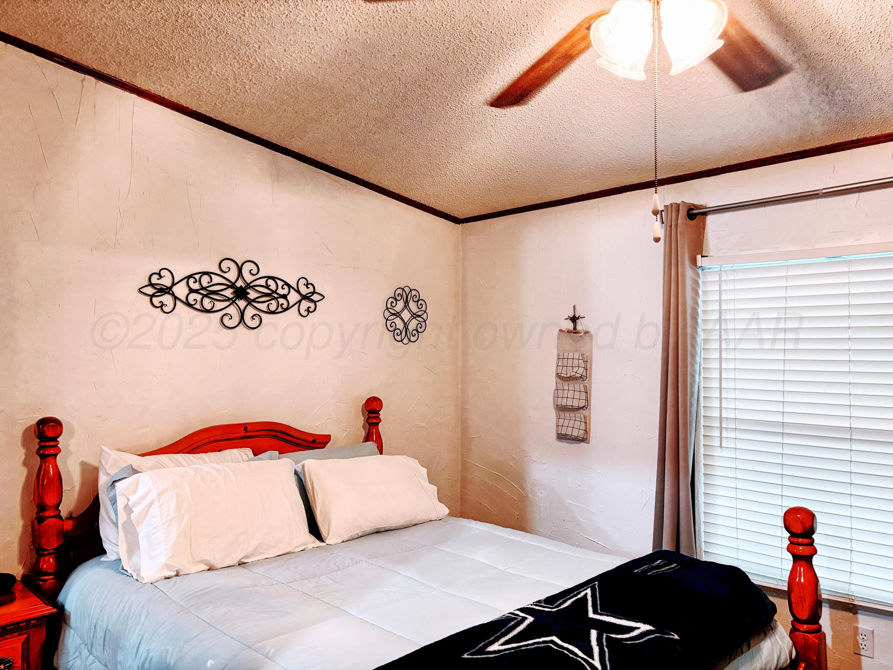 1010 South Baylor Street Perryton, TX 79070 - Photo 13 of 35 a bedroom with a bed and a painting on the wall