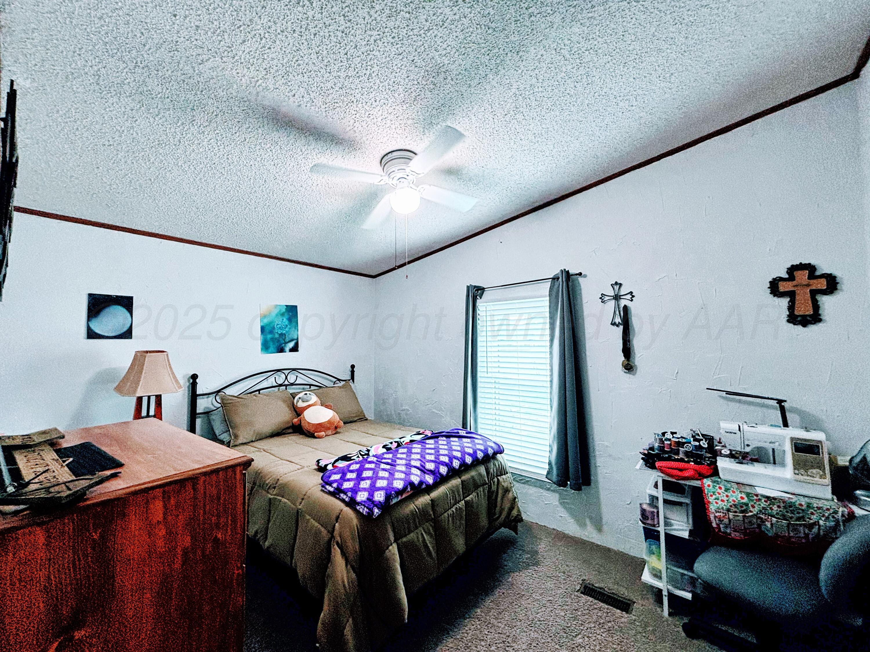 1010 South Baylor Street Perryton, TX 79070 - Photo 24 of 35 a bedroom with furniture and a chandelier