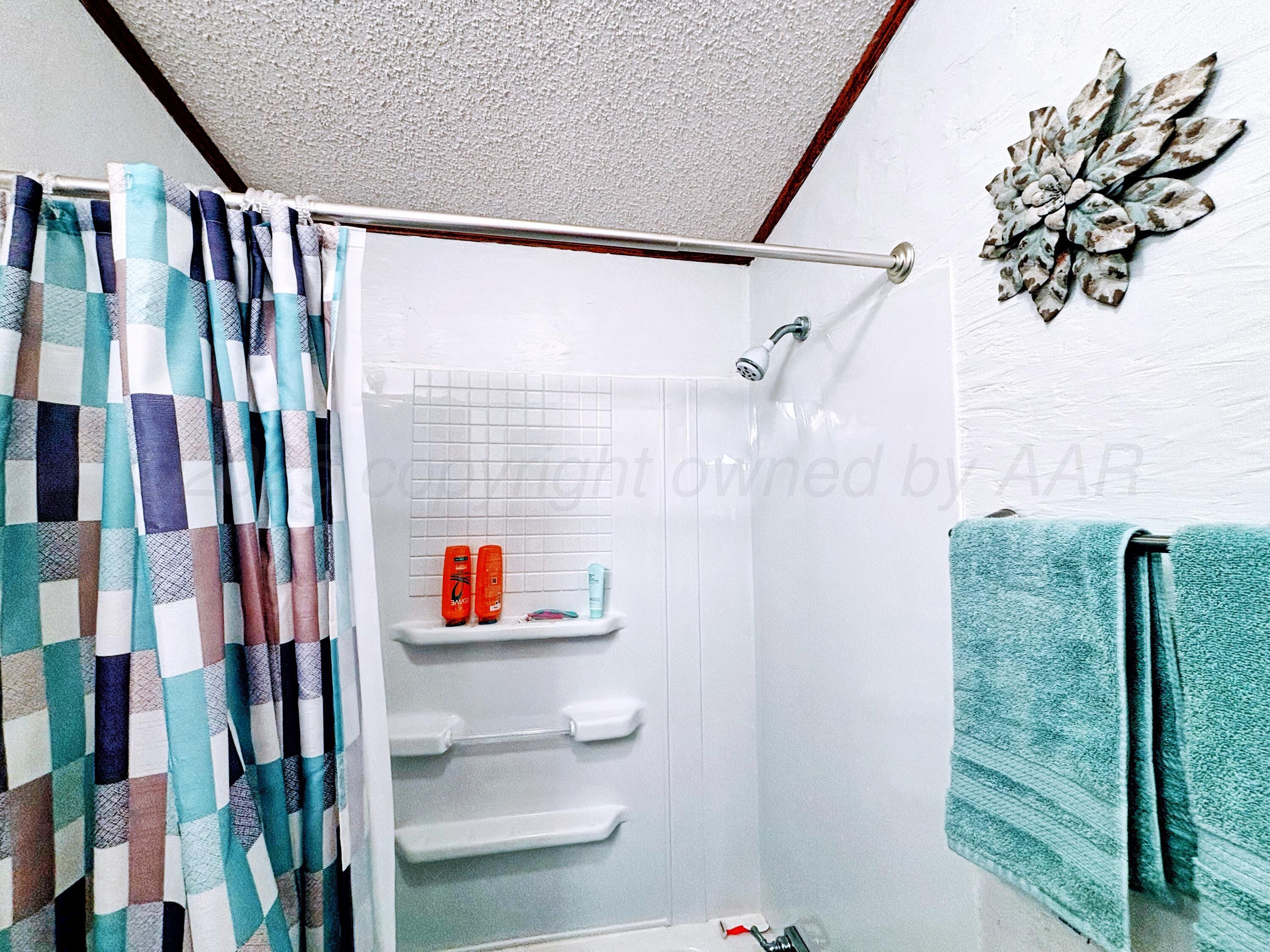 1010 South Baylor Street Perryton, TX 79070 - Photo 27 of 35 a bathroom with a shower and a shower curtain