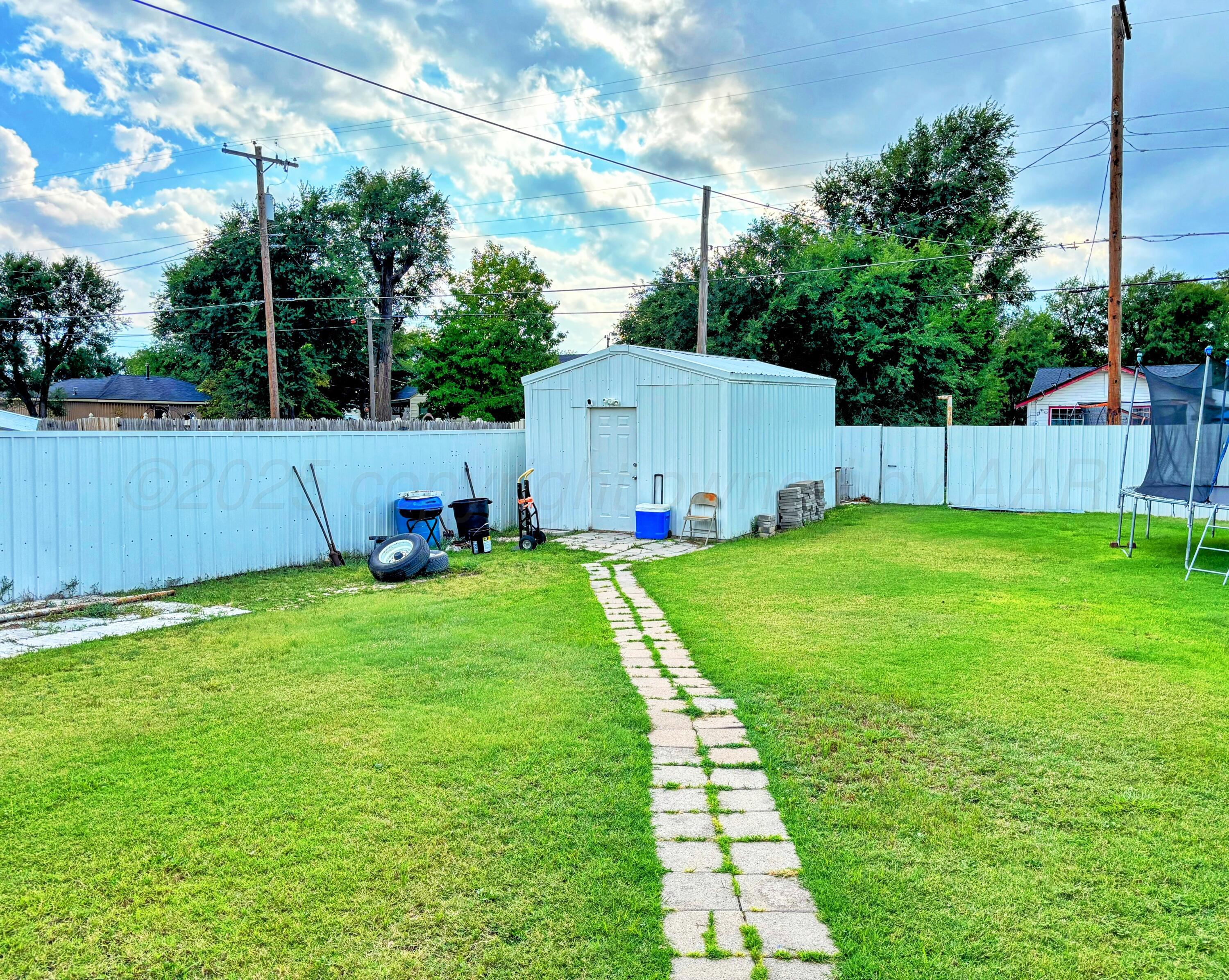1010 South Baylor Street Perryton, TX 79070 - Photo 30 of 35 a backyard with potted plants and a large tree