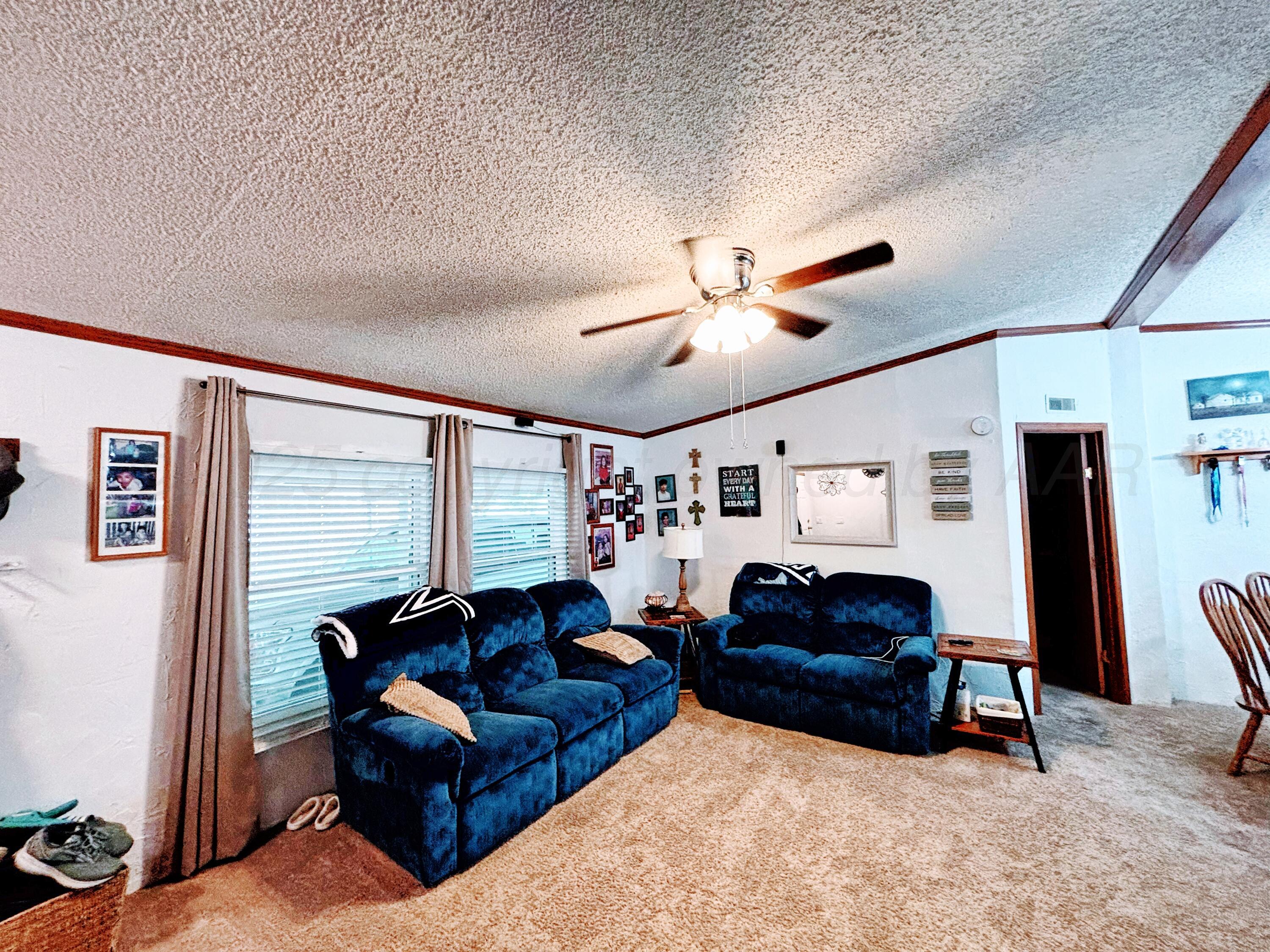 1010 South Baylor Street Perryton, TX 79070 - Photo 6 of 35 a living room with furniture a ceiling fan and a window