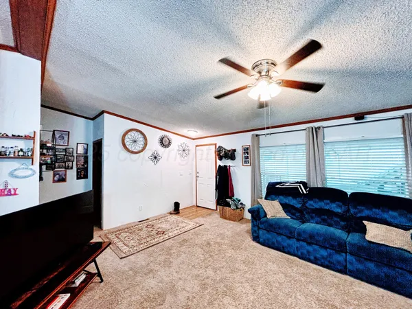 a living room with furniture and a ceiling fan