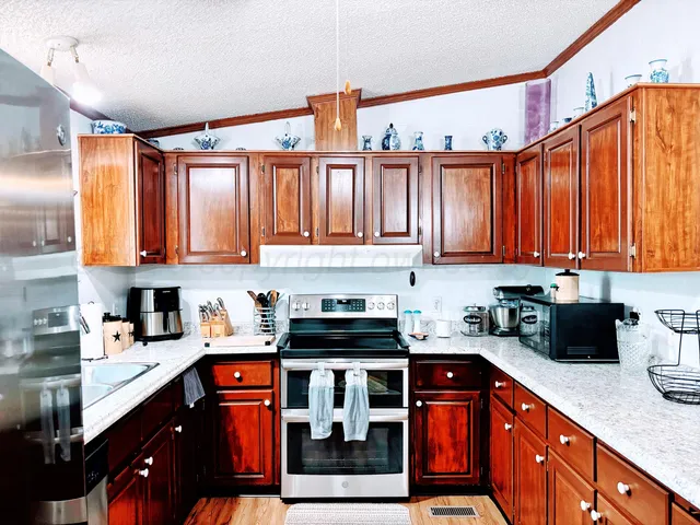 a kitchen with stainless steel appliances granite countertop a sink stove and cabinets