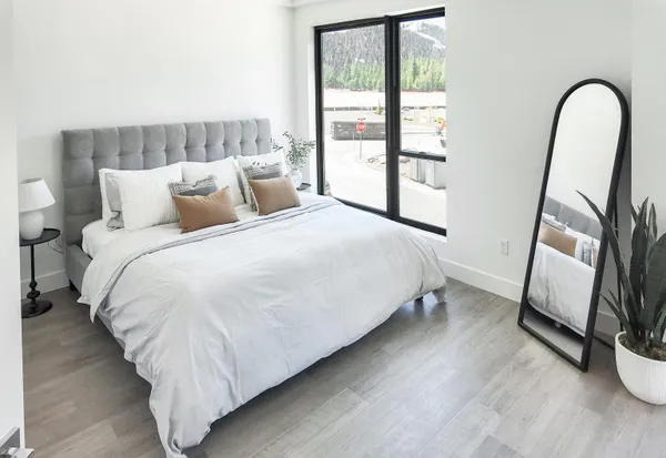a bedroom with a bed and a large window