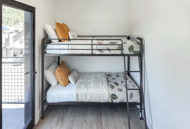 a bedroom with a bunk bed and wooden floor