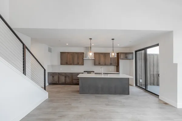 a large kitchen with stainless steel appliances a large counter top and a refrigerator