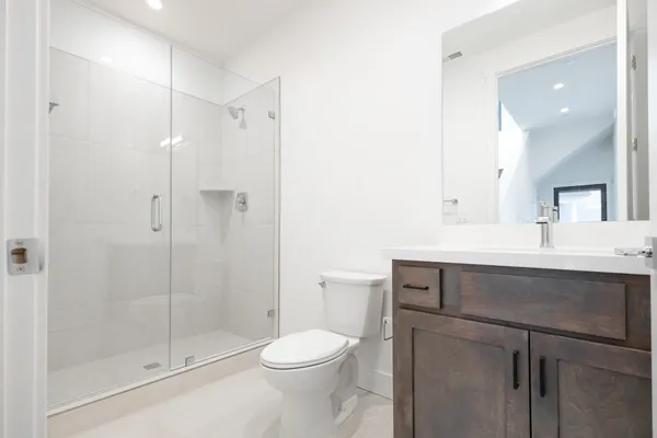 a bathroom with a sink toilet vanity and shower