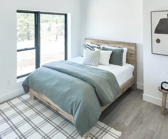 a large bed sitting in a bedroom next to a window