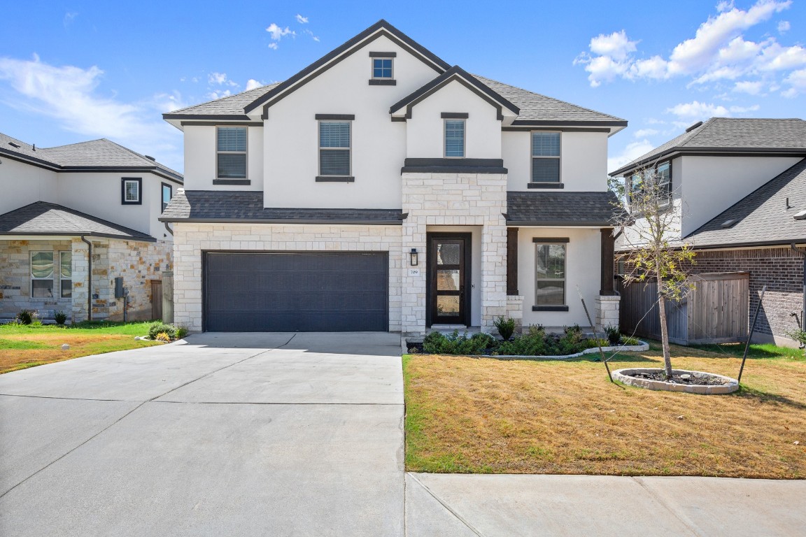 a front view of a house with a yard and garage
