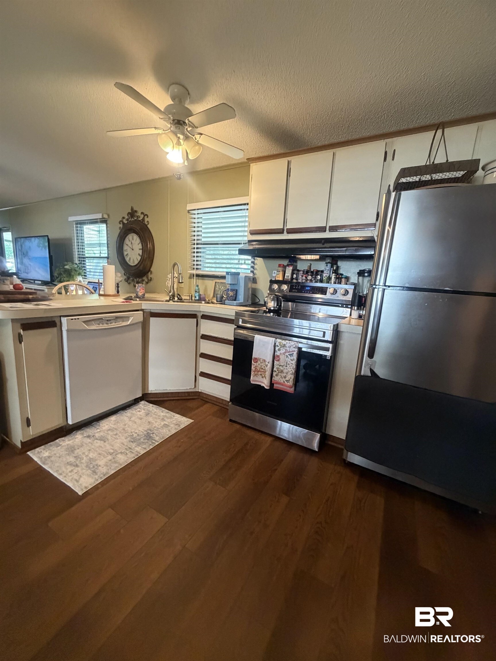 1620 Del Rey Drive Lillian, AL 36549 - Photo 12 of 45 Kitchen featuring wood-finish flooring, white cabinetry, and stainless steel appliances