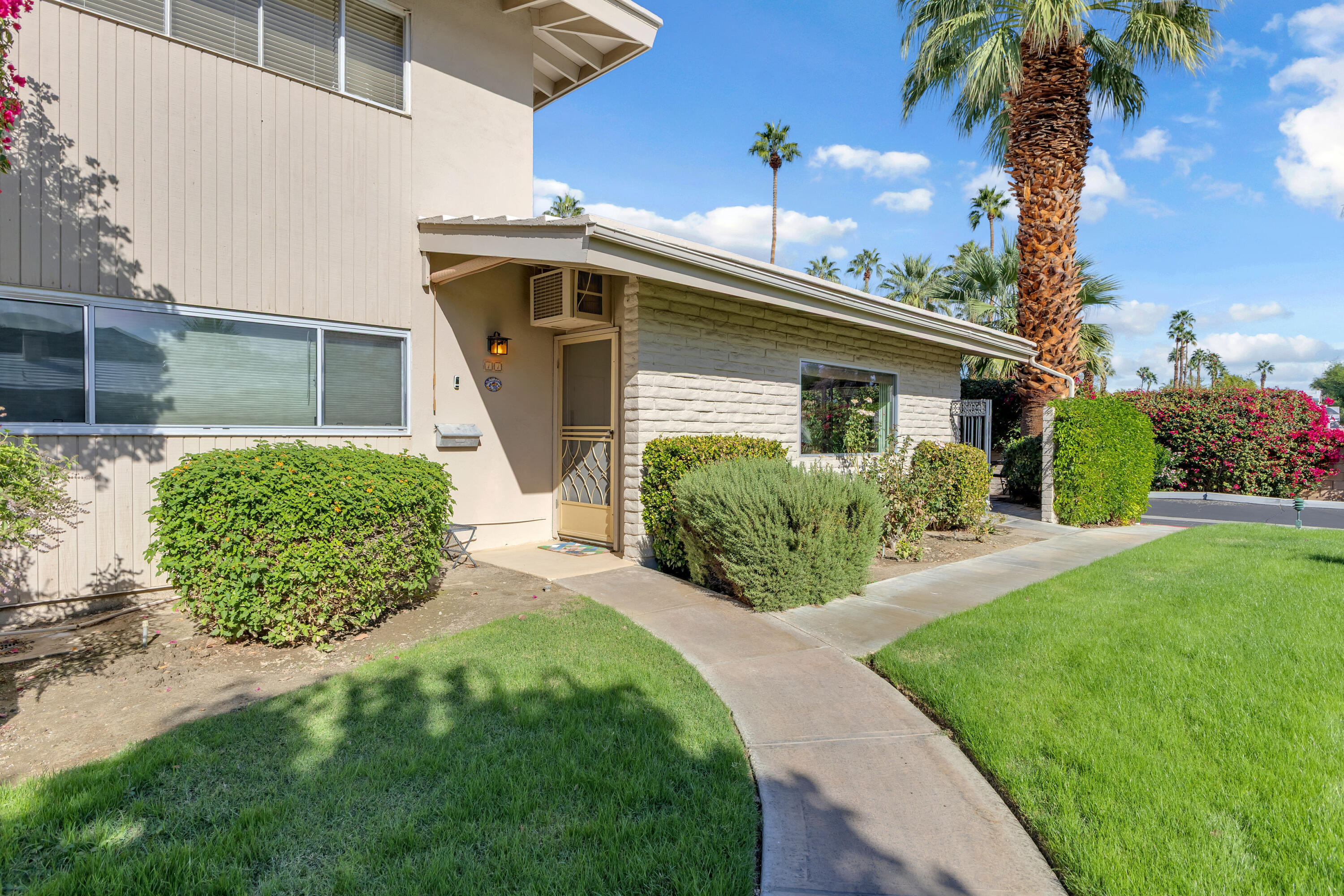 69850 Hwy 111 Rancho Mirage Ca, Unit 11 Rancho Mirage, CA 92270 - Photo 1 of 48 a front view of a house with garden