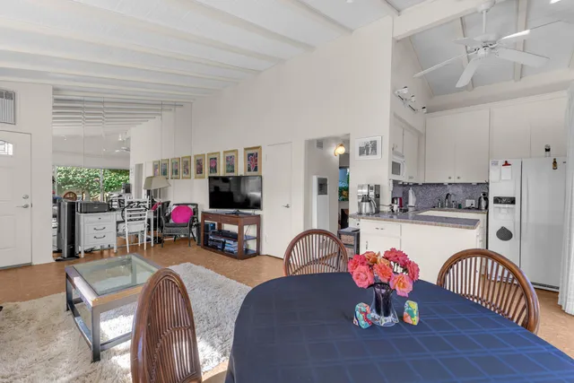 a kitchen with stainless steel appliances a dining table chairs and a refrigerator