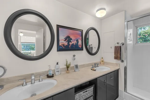 a bathroom with a granite countertop double vanity and a mirror