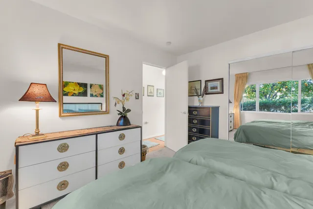 a bedroom with a bed and a lamp on dresser