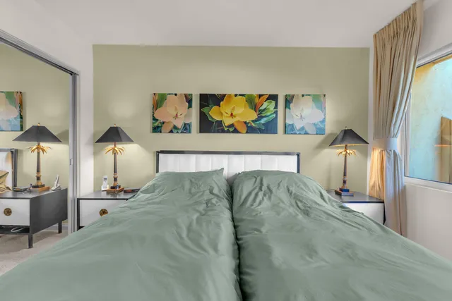 a bedroom with a bed and a painting on the wall
