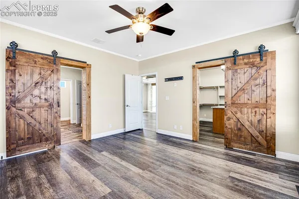 a view of empty room with wooden floor and fan