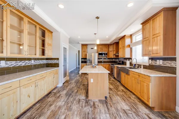 a large kitchen with stainless steel appliances granite countertop a large stove a sink dishwasher and a oven with white cabinets