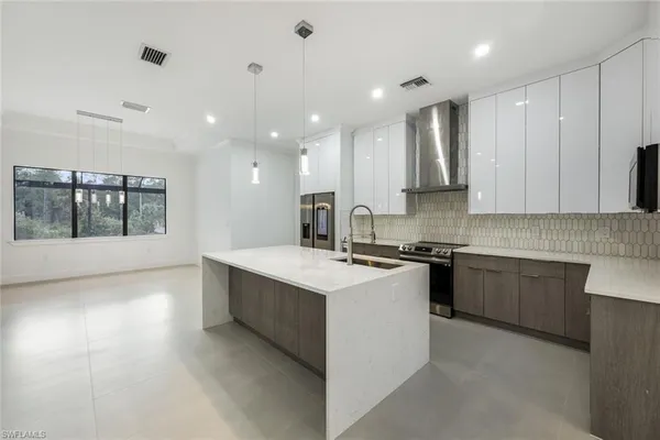 a large kitchen with stainless steel appliances granite countertop a stove a sink and a microwave