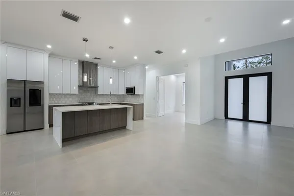 a large kitchen with a large counter top stainless steel appliances and cabinets