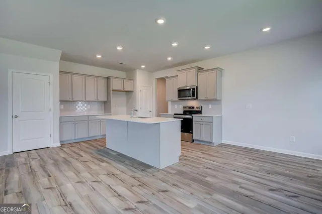 a kitchen with a refrigerator and a stove top oven