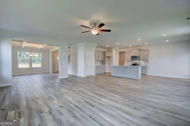 a view of an empty room with window and wooden floor