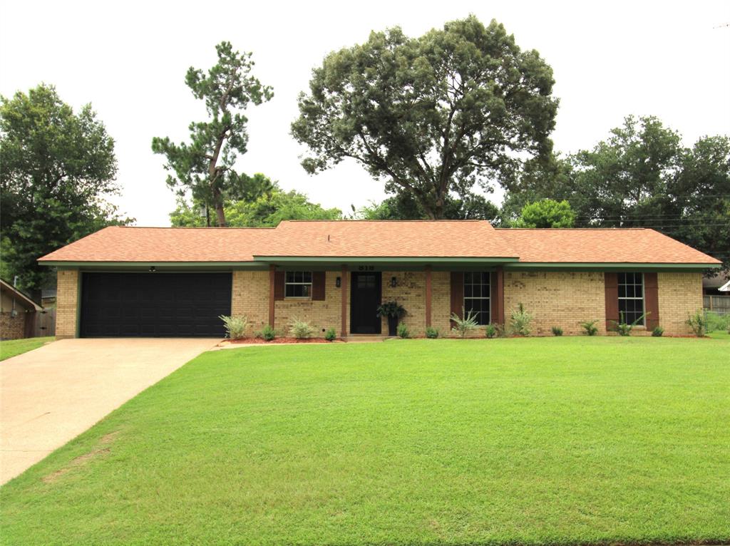 818 East Clinton Avenue Athens, TX 75751 - Photo 1 of 24 a front view of a house with a yard and garage