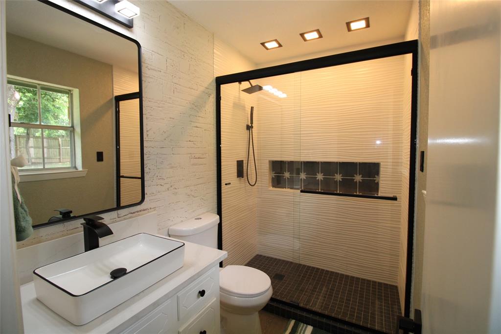 818 East Clinton Avenue Athens, TX 75751 - Photo 18 of 24 a bathroom with a sink a toilet and a mirror